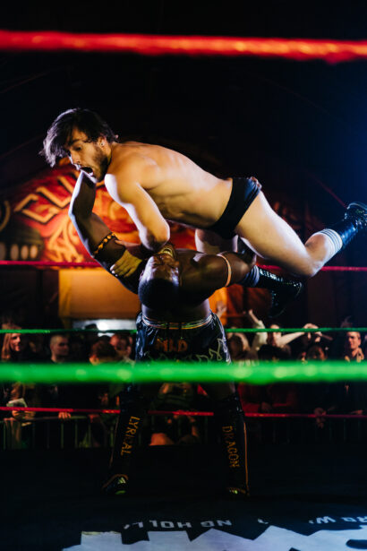 Worstelaar tilt tegenstander hoog in de lucht tijdens Markt Kabaal x Pro Wrestling Holland in Markt Centraal