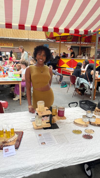 Meisje staat achter haar kraampje van Kimco Superfood tijdens de Markt Kabaal x Soul2Soul markt in Markt Centraal, Amsterdam.